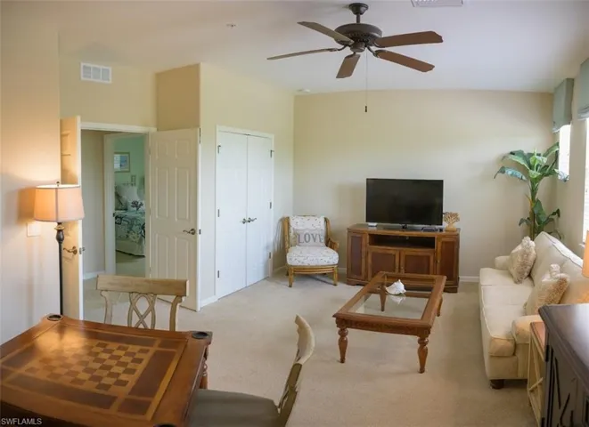 Carpeted living room featuring ceiling fan