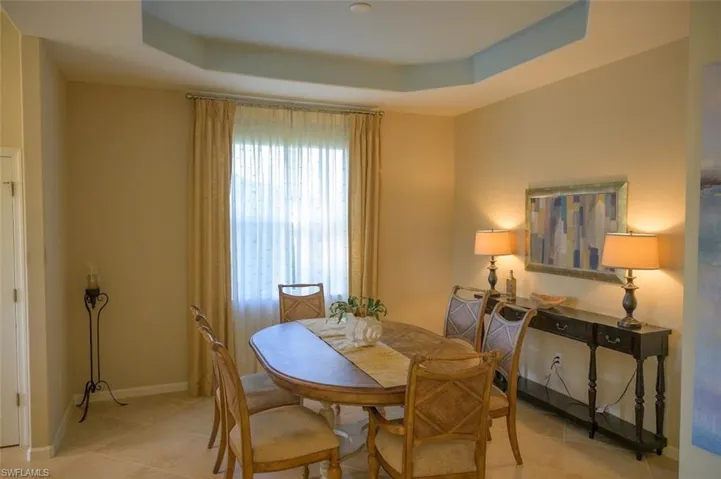 Dining space featuring a raised ceiling and light tile patterned flooring