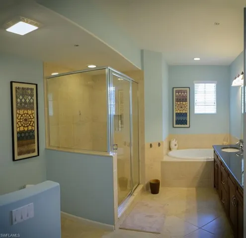 Bathroom with tile patterned floors, vanity, and independent shower and bath