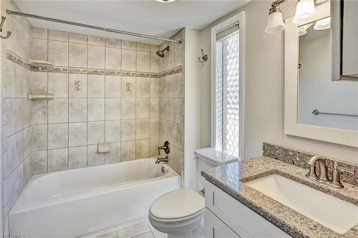 Bathroom featuring vanity, bathtub / shower combination, and light tile patterned floors