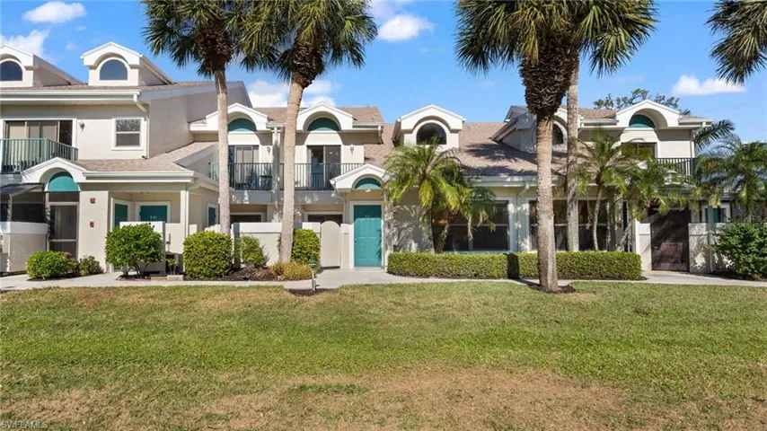 View of front of house with a balcony and a front lawn