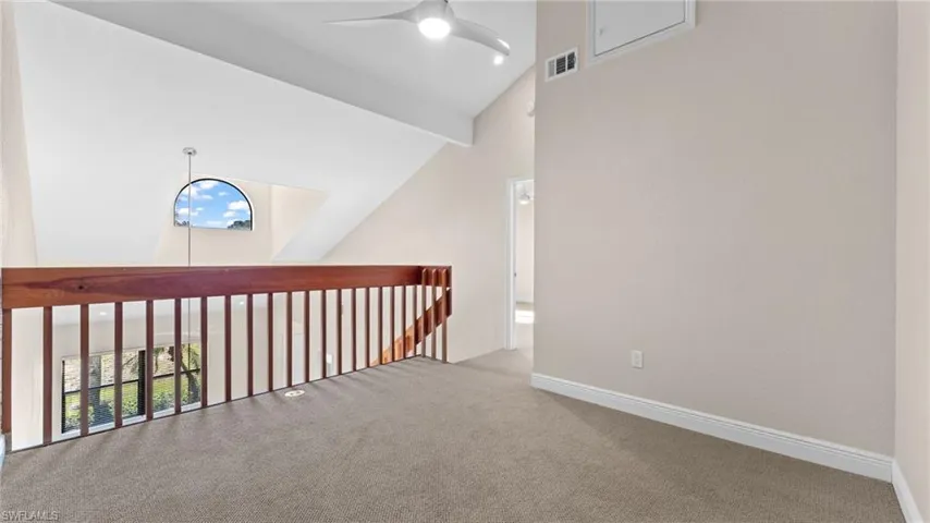 Hallway with carpet flooring, high vaulted ceiling, and beam ceiling