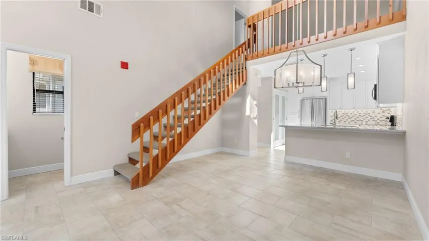 Staircase with sink, a towering ceiling, and a notable chandelier
