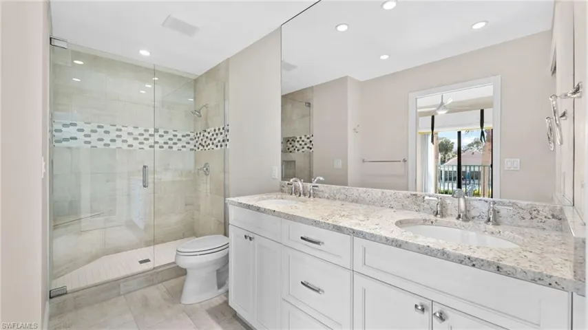 Bathroom with vanity, toilet, and an enclosed shower