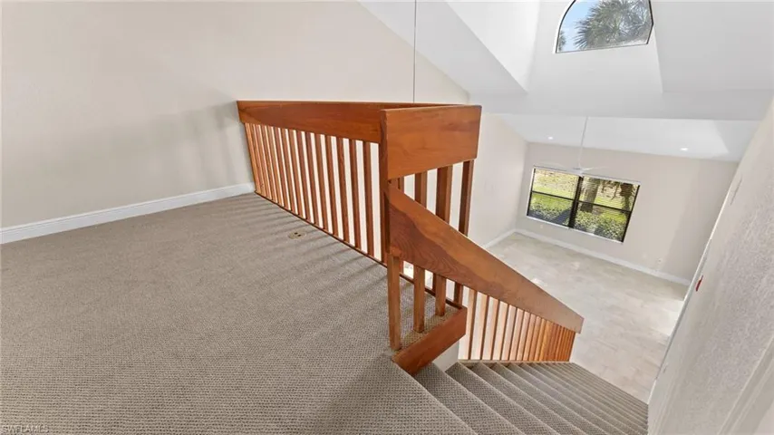 Stairway featuring carpet floors, high vaulted ceiling, and ceiling fan