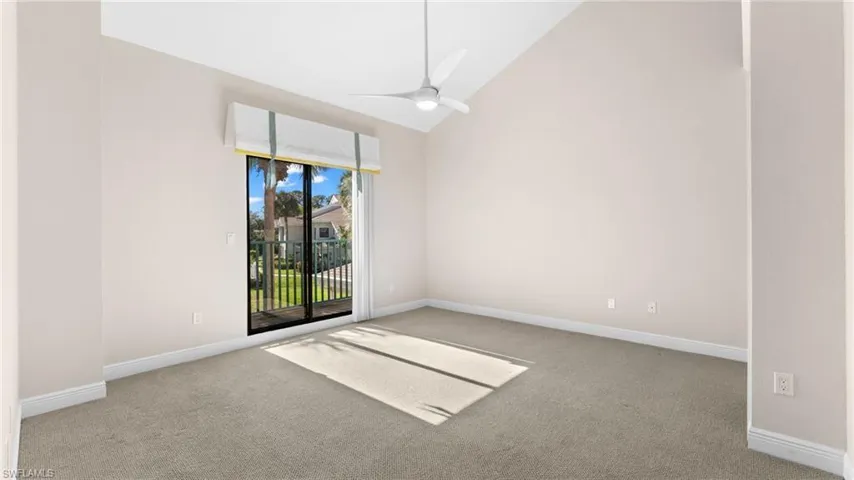 Spare room featuring ceiling fan, light carpet, and high vaulted ceiling