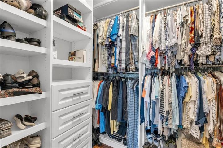 Walk in closet w/ custom shelving, drawers and cabinets.