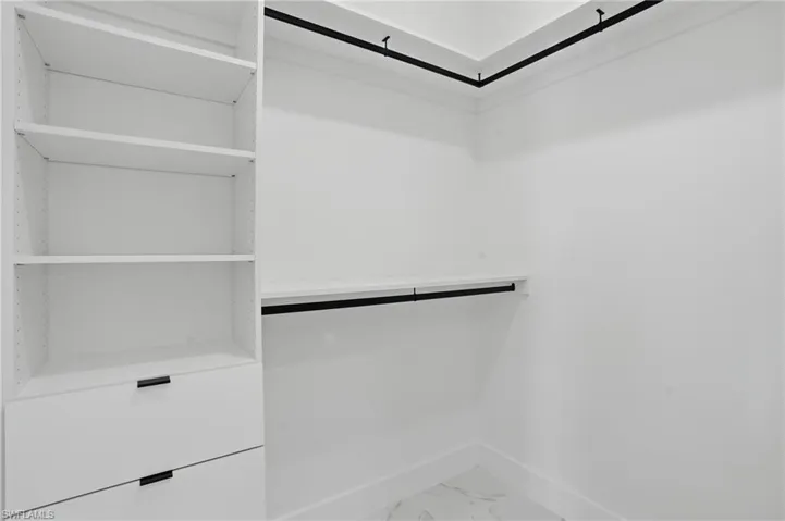 Spacious closet with light marble finish flooring