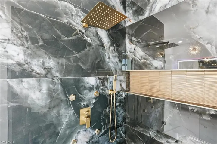 Bathroom view of a marble finish shower and tile walls