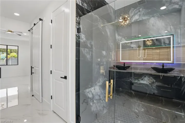 Full bathroom with marble tiled floors, a marble finish shower, ceiling fan, recessed lighting, and vanity