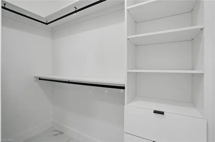 Walk in closet with marble finish floors