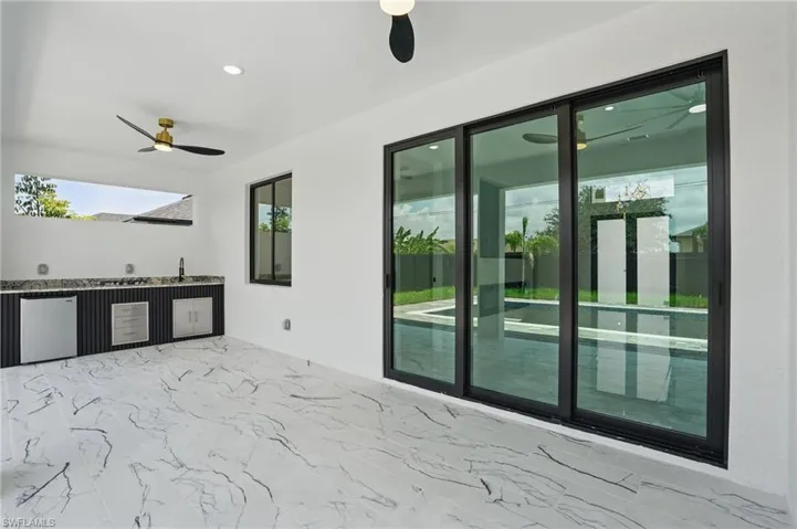 View of patio / terrace featuring ceiling fan, exterior kitchen, and a sink