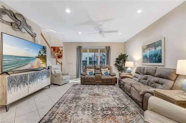 Living area featuring ceiling fan, light tile patterned flooring, and recessed lighting