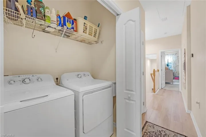Laundry area featuring light wood-style floors and washing machine and dryer