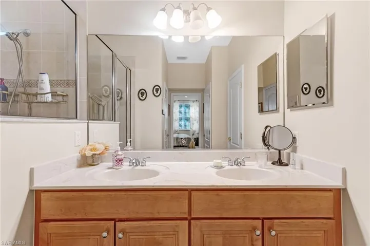 Ensuite bathroom featuring double vanity and a stall shower
