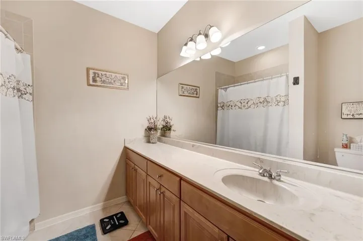 Bathroom with a shower with shower curtain, vanity, and light tile patterned flooring