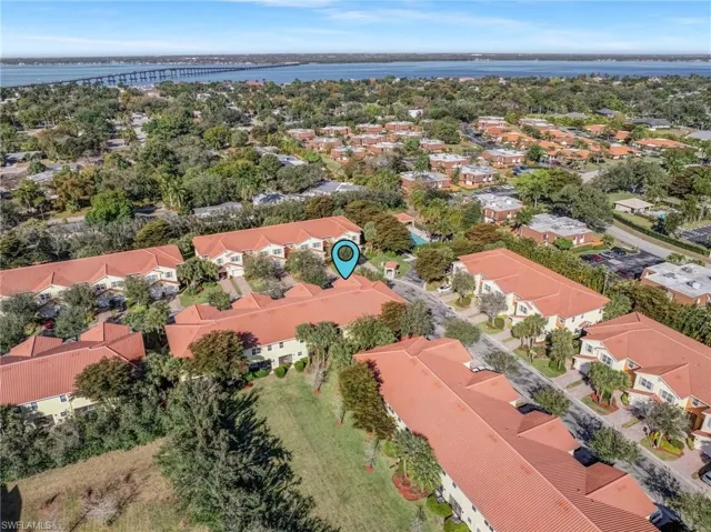Aerial perspective of suburban area with a large body of water and a notable bridge