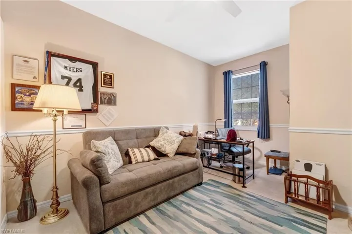 Living room with carpet and a ceiling fan