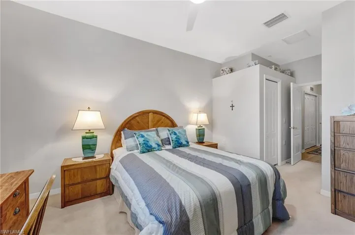 Bedroom featuring light colored carpet, ceiling fan, and a closet