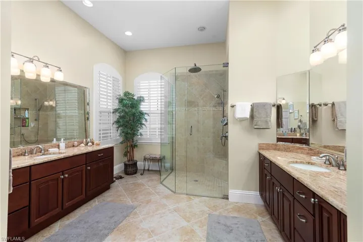 Bathroom featuring vanity, walk in shower, and tile patterned flooring