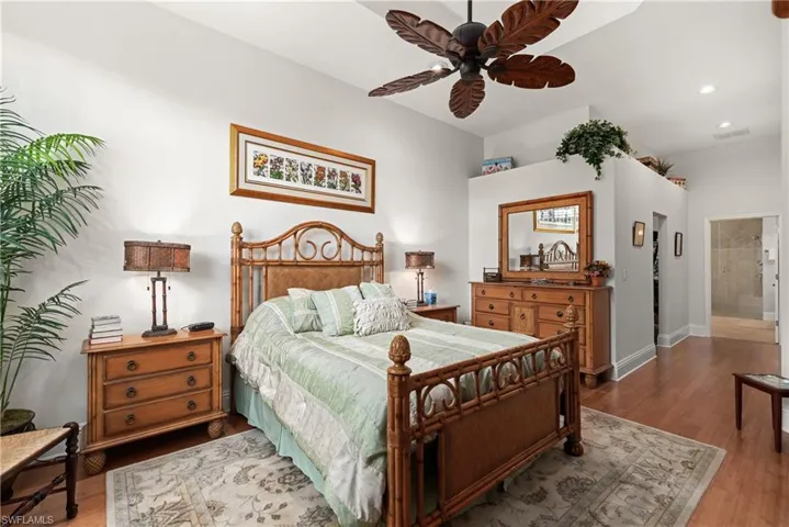 Bedroom featuring ceiling fan, ensuite bathroom, and hardwood / wood-style floors