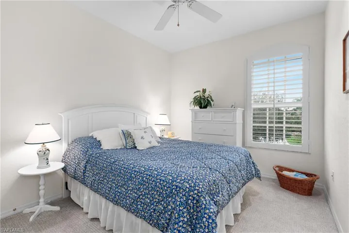 Bedroom with ceiling fan and light carpet