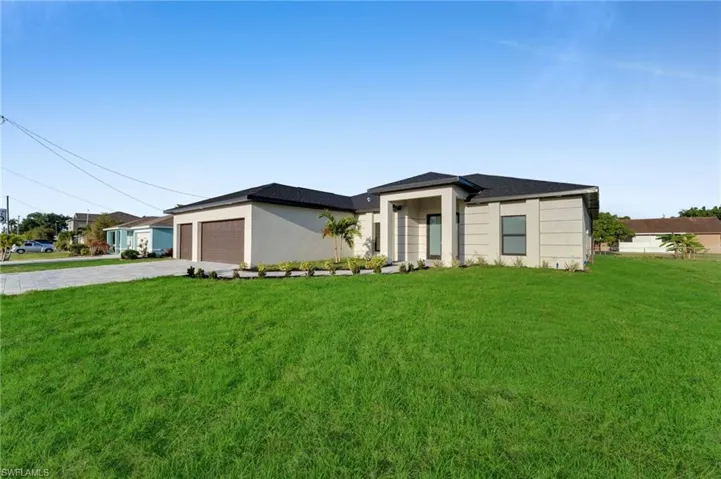 Prairie-style house featuring driveway, a front yard, and a garage