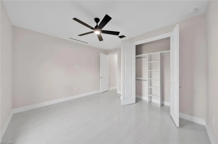 Unfurnished bedroom featuring a closet, visible vents, a ceiling fan, and baseboards