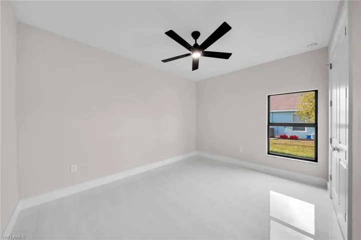 Empty room featuring baseboards and a ceiling fan