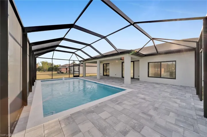 Pool featuring glass enclosure and a patio area