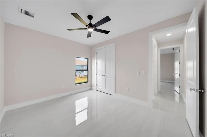 Unfurnished bedroom featuring a closet, visible vents, a ceiling fan, and baseboards