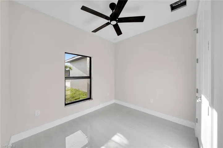 Unfurnished room featuring a ceiling fan and baseboards
