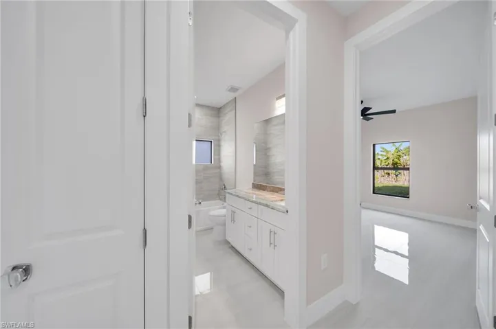 Bathroom with tile patterned floors, toilet, vanity, visible vents, and a ceiling fan