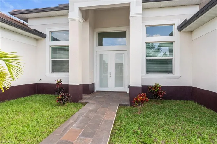 Property entrance featuring front yard, stucco siding and french doors!