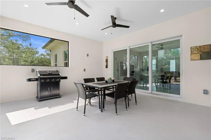PART II: Another angle of this outdoor dining space featuring concrete flooring, ceiling fans