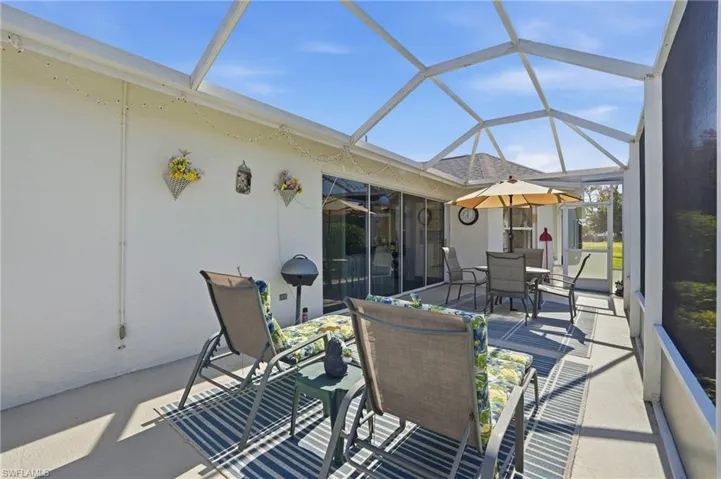 View of patio / terrace with a sunroom, outdoor dining space, and a lanai