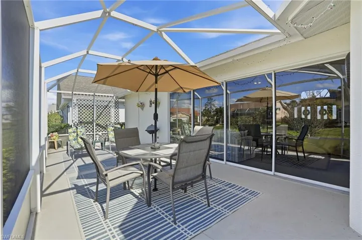 View of patio / terrace featuring a sunroom, outdoor dining area, and glass enclosure