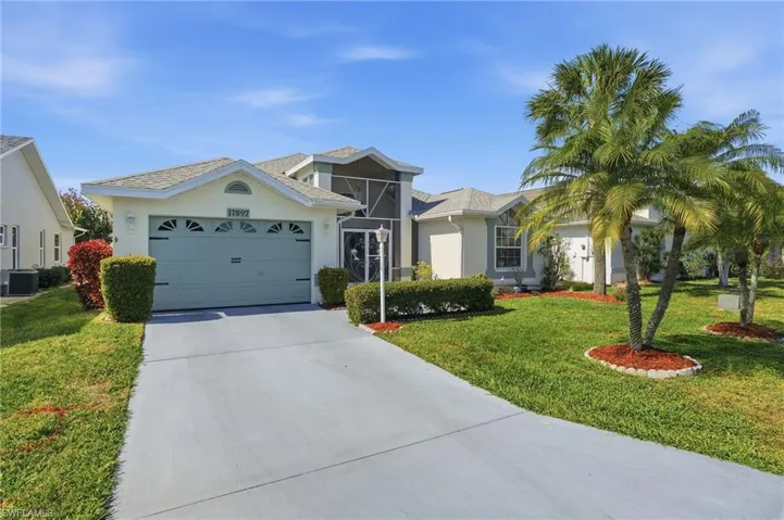 View of front of home with driveway, a front yard, stucco siding, and an attached garage
