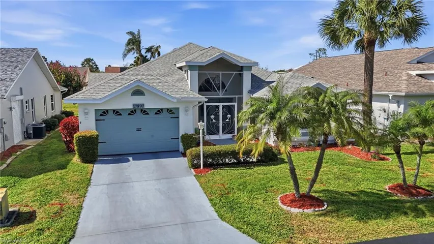 View of front facade with an attached garage, concrete driveway, roof with shingles, stucco siding, and a front yard