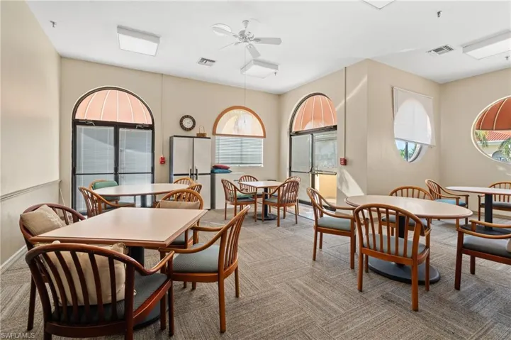 Dining area with a ceiling fan and light colored carpet