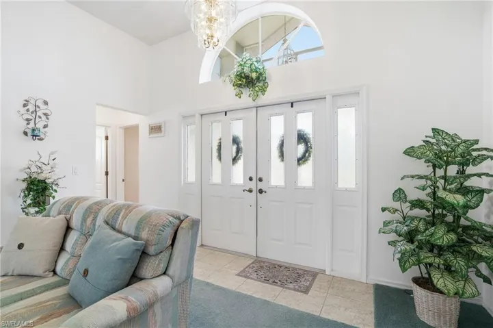 Tiled entrance foyer featuring a towering ceiling and a chandelier