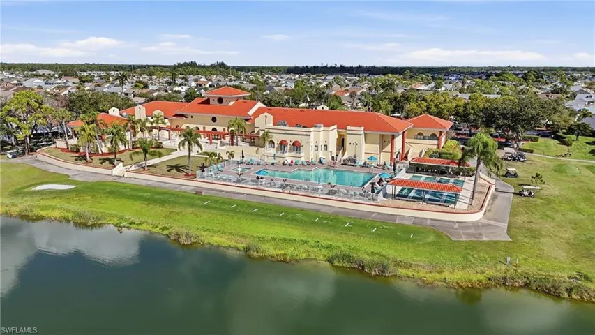 Aerial view of residential area featuring a nearby body of water and a pool