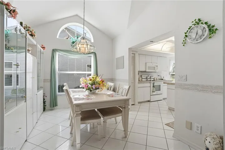 Dining room featuring light tile patterned flooring and lofted ceiling