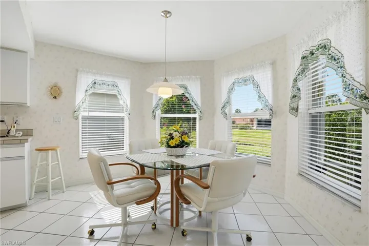Dining space with light tile patterned floors and wallpapered walls