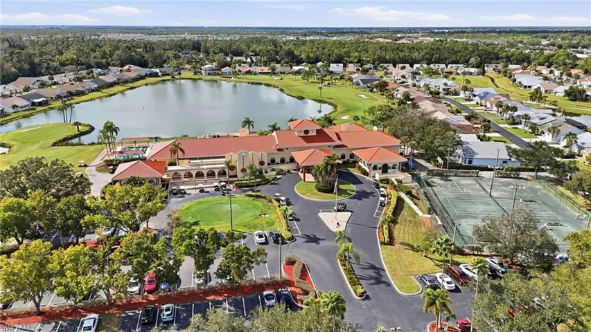 Aerial view of property and surrounding area with a nearby body of water, nearby suburban area, and a golf course