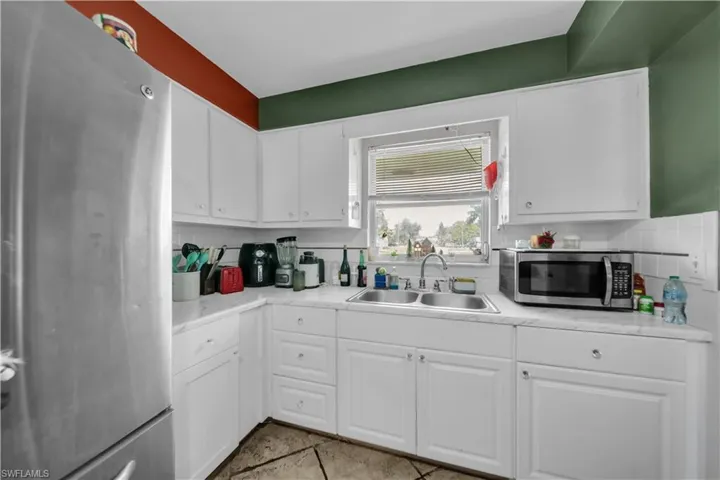 Kitchen featuring white cabinetry, a tiled backsplash, and a ceiling fan