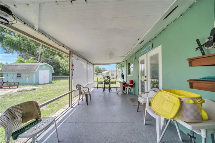 Laundry area featuring a water heater, shelving, and a side door with a window