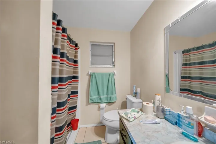 Interior room featuring tile flooring, neutral wall paint, and a white ceiling fan with light fixture