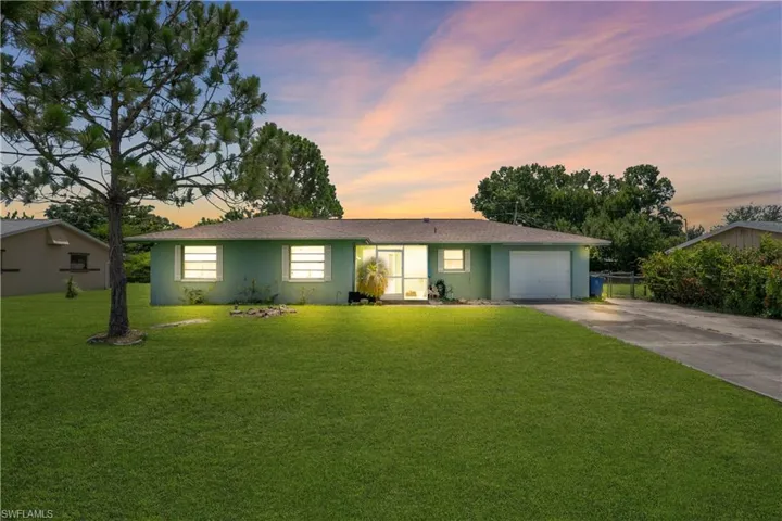 Single-story residence featuring a light green exterior and a brown shingle roof