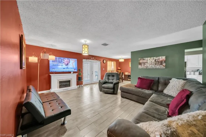 Open-concept living area featuring a mix of wood-finish flooring and patterned tile